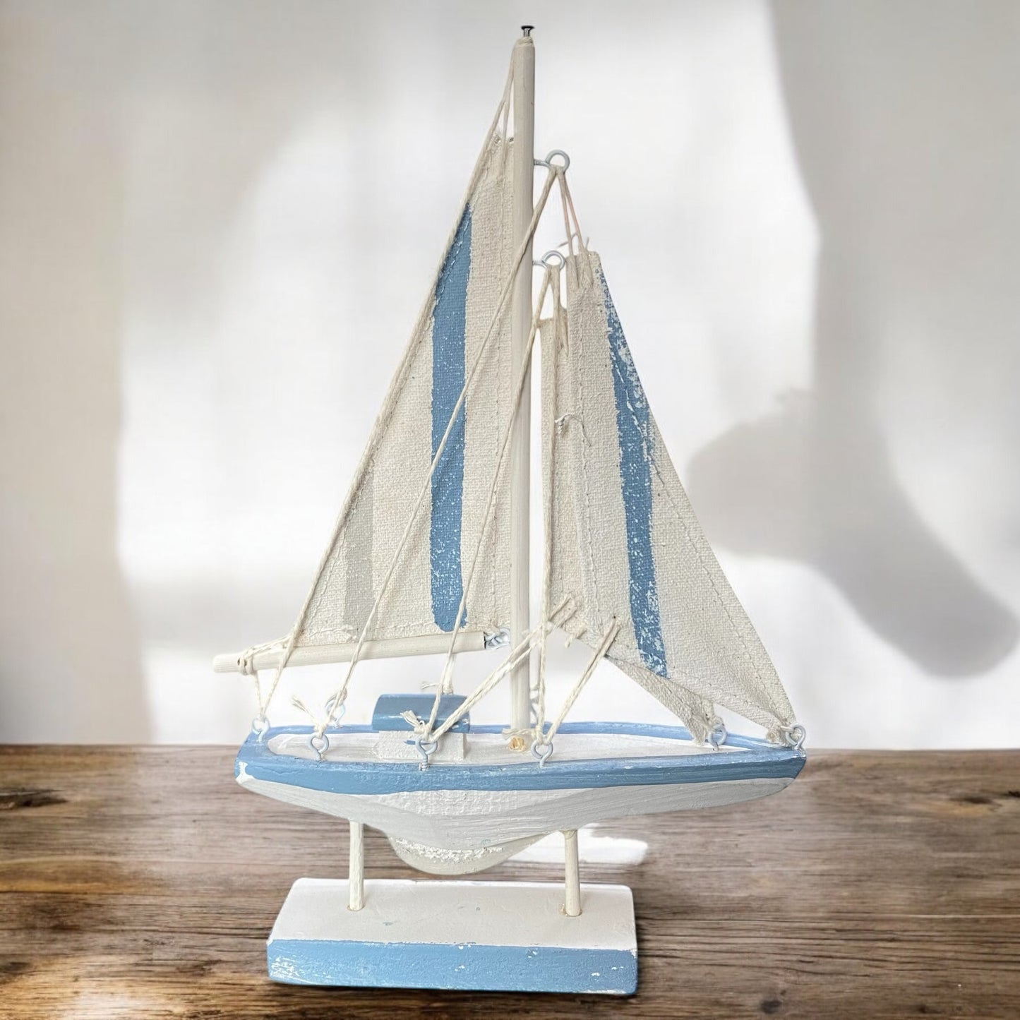 Blau-weißes Deko Segelboot aus Holz mit Stoffsegeln im Ambiente