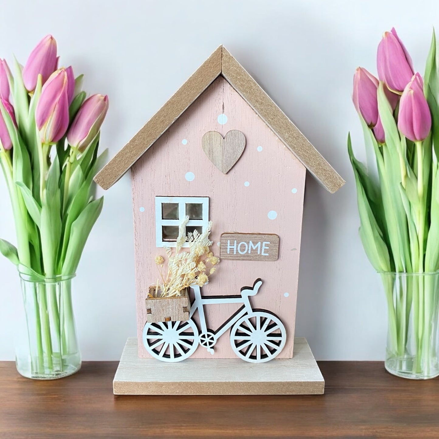 Aufsteller Haus aus Holz in Rosa mit Deko-Elementen wie Fahrrad und Trockenblumen im Ambiente