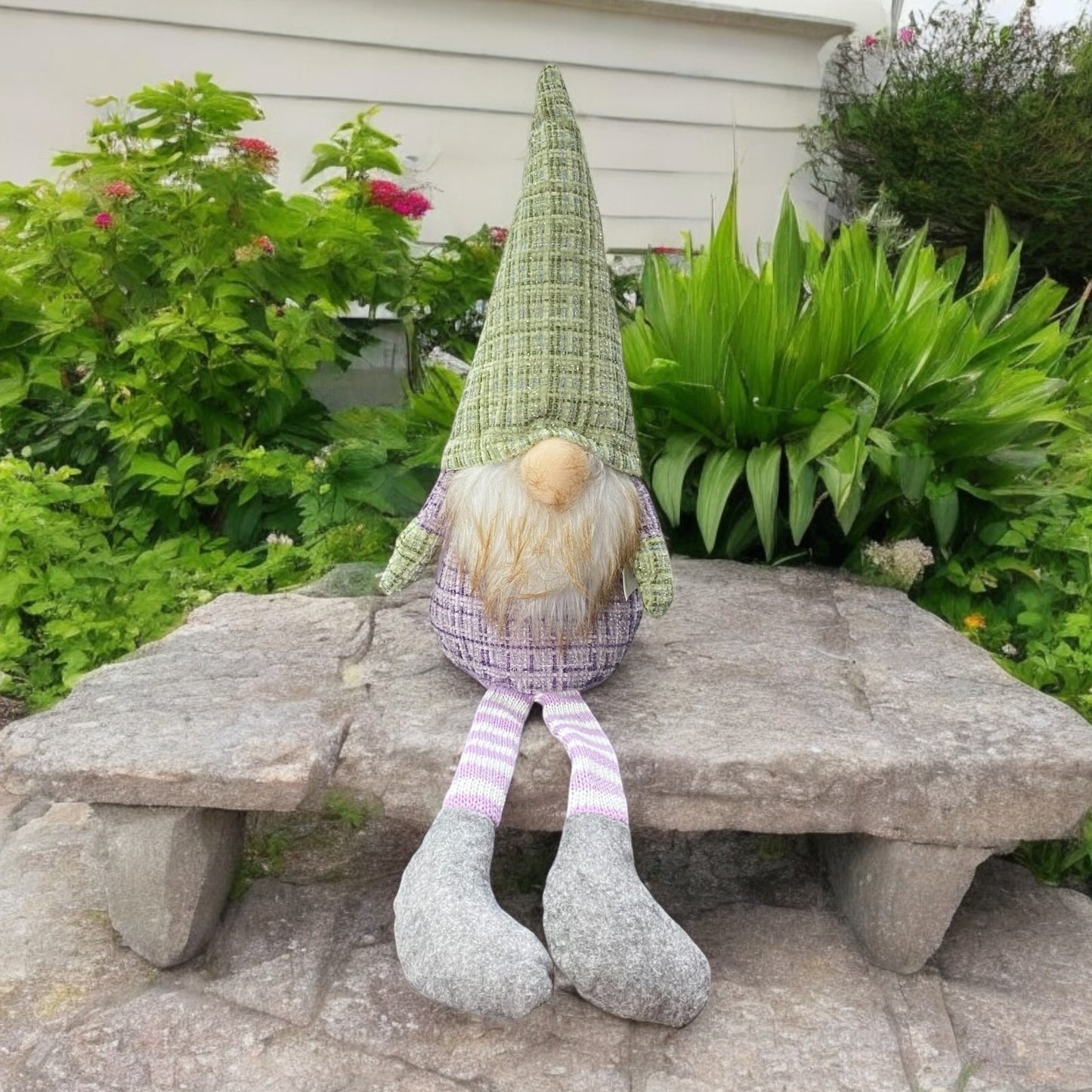 Ein Deko Stoff Wichtel Kantensitzer mit grüner Zipfelmütze und lila Körper im Ambiente