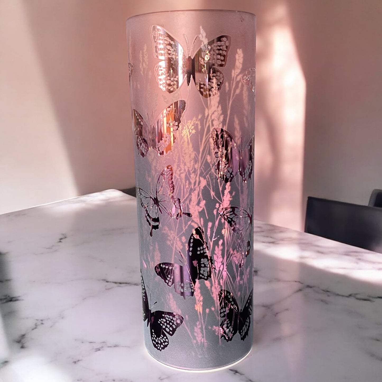 Große LED Säule in lila mit Schmetterlingen und Blumen im Ambiente platziert