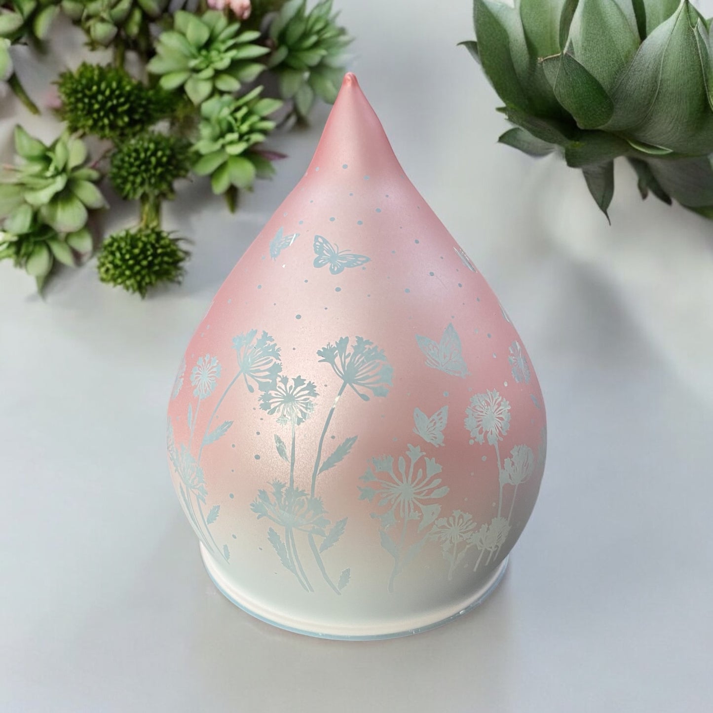 LED Glastropfen in rosa mit Schmetterlingen und Blumen im Ambiente platziert
