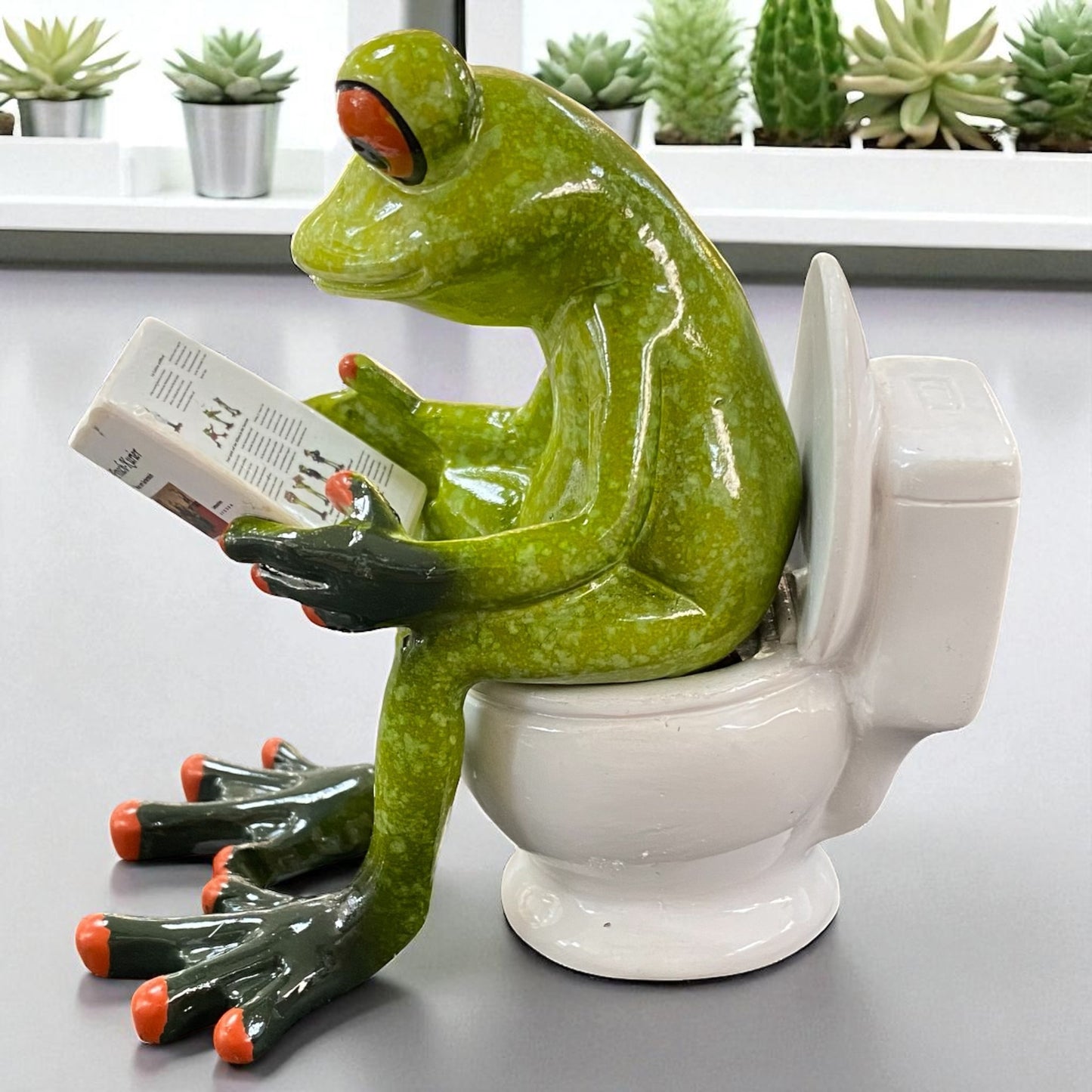 Formano Froschhausen Dekofigur Frosch auf Toilette mit Zeitung in der Hand im Ambiente seitliche Ansicht