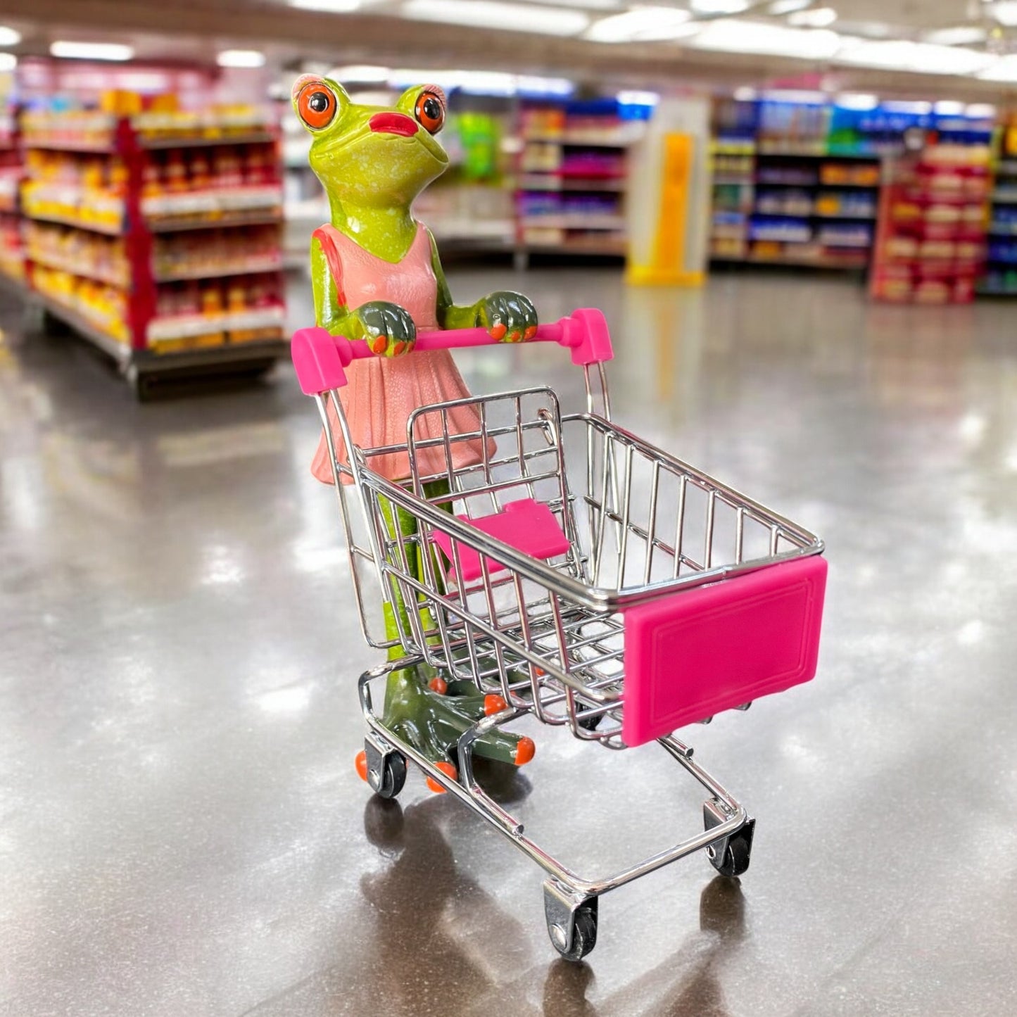 Eine witzige Formano Frosch Figur als Frosch-Dame mit pinkem Einkaufswagen und rosa Kleid im Ambiente.