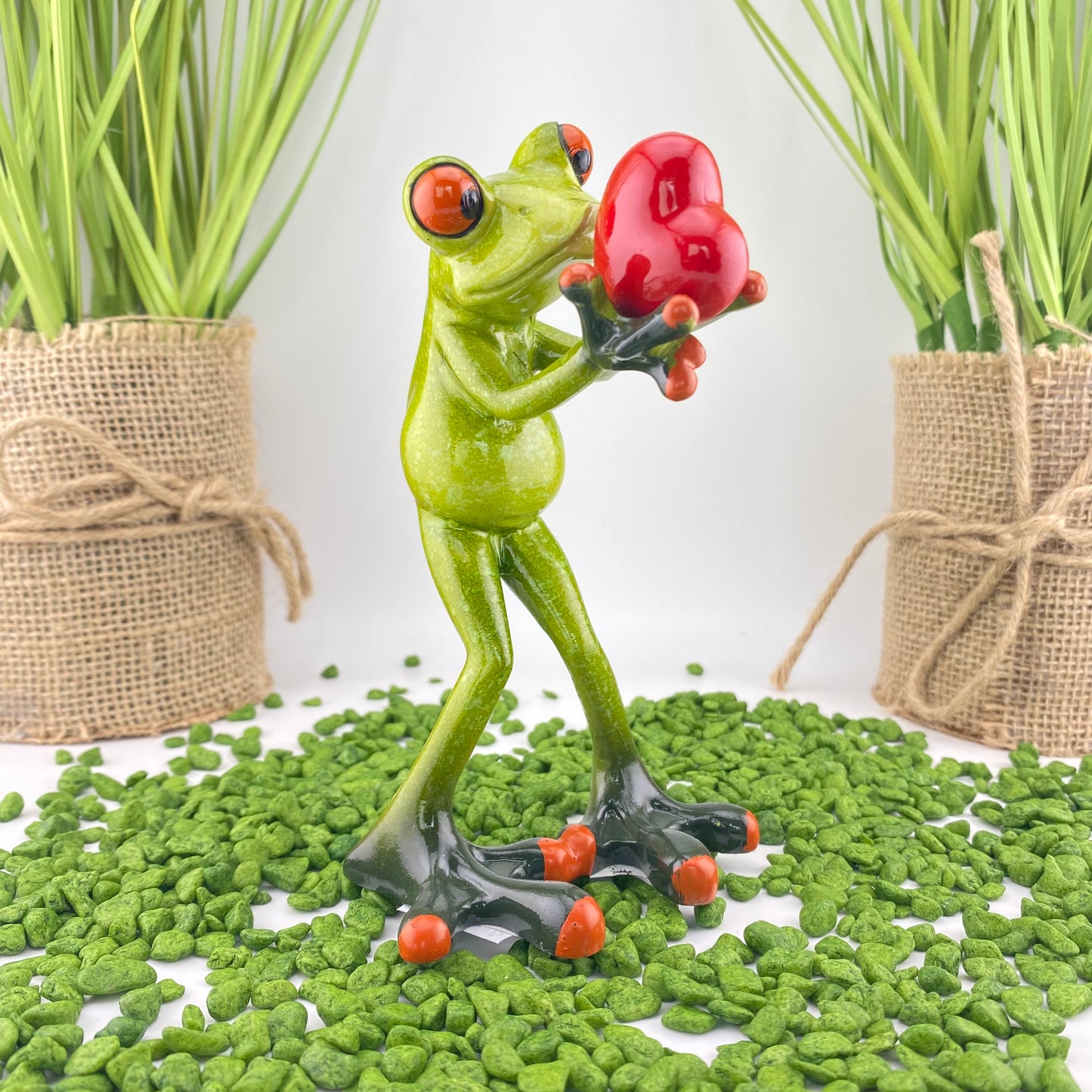 Ein verliebter Dekofigur Frosch der Serie Froschhausen mit einem roten Herz in der Hand ist im Ambiente platziert.