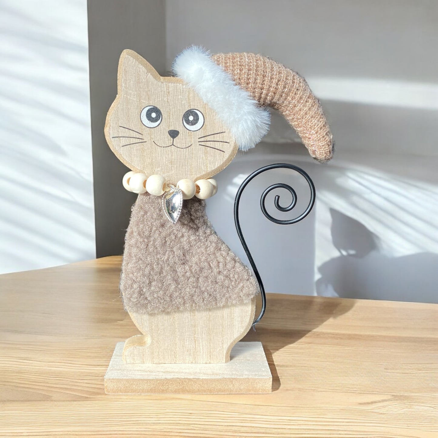 Holzkatze mit Wintermütze in braun im Ambiente platziert