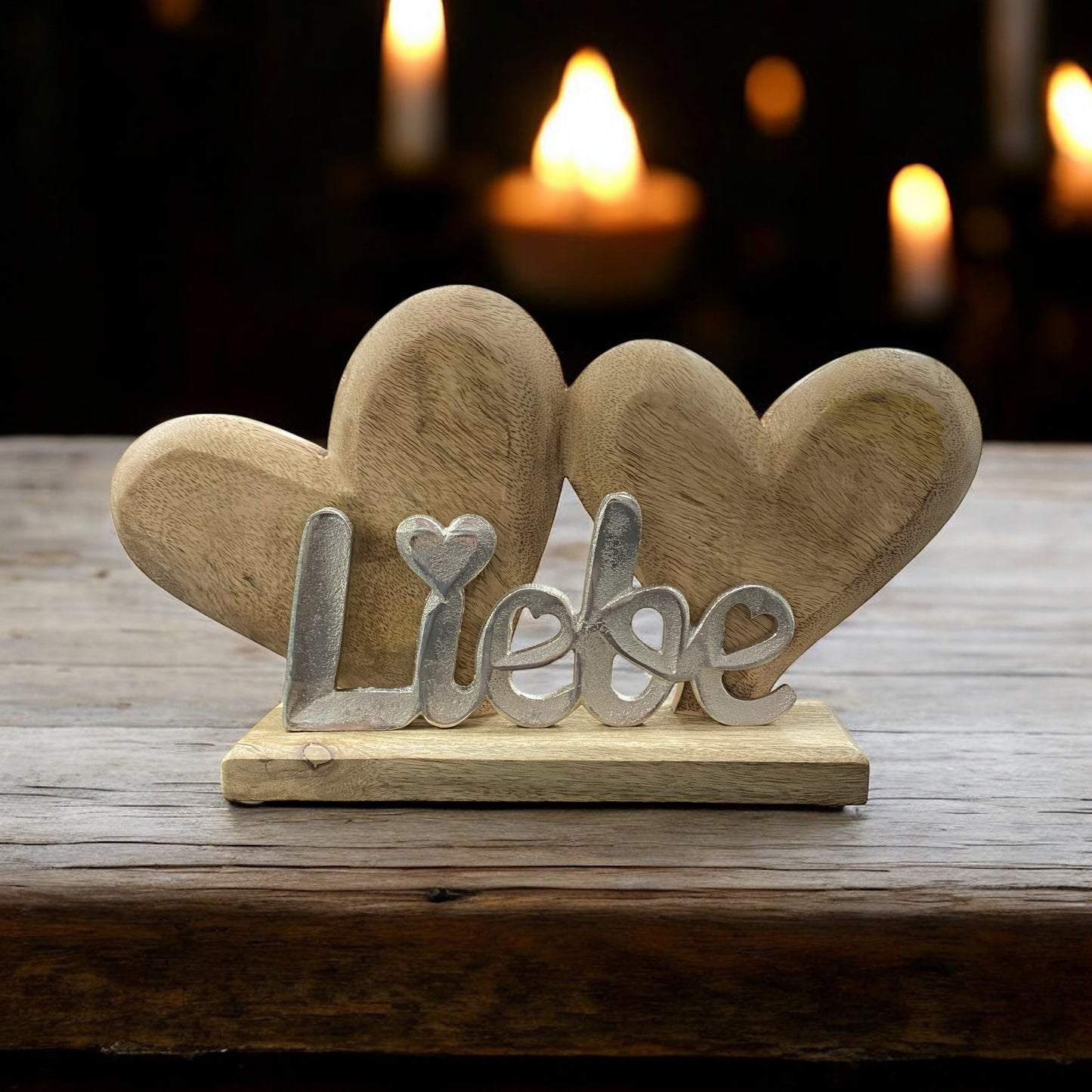 Ein Holz Dekoaufsteller aus zwei Herzen mit Schriftzug Liebe im Ambiente