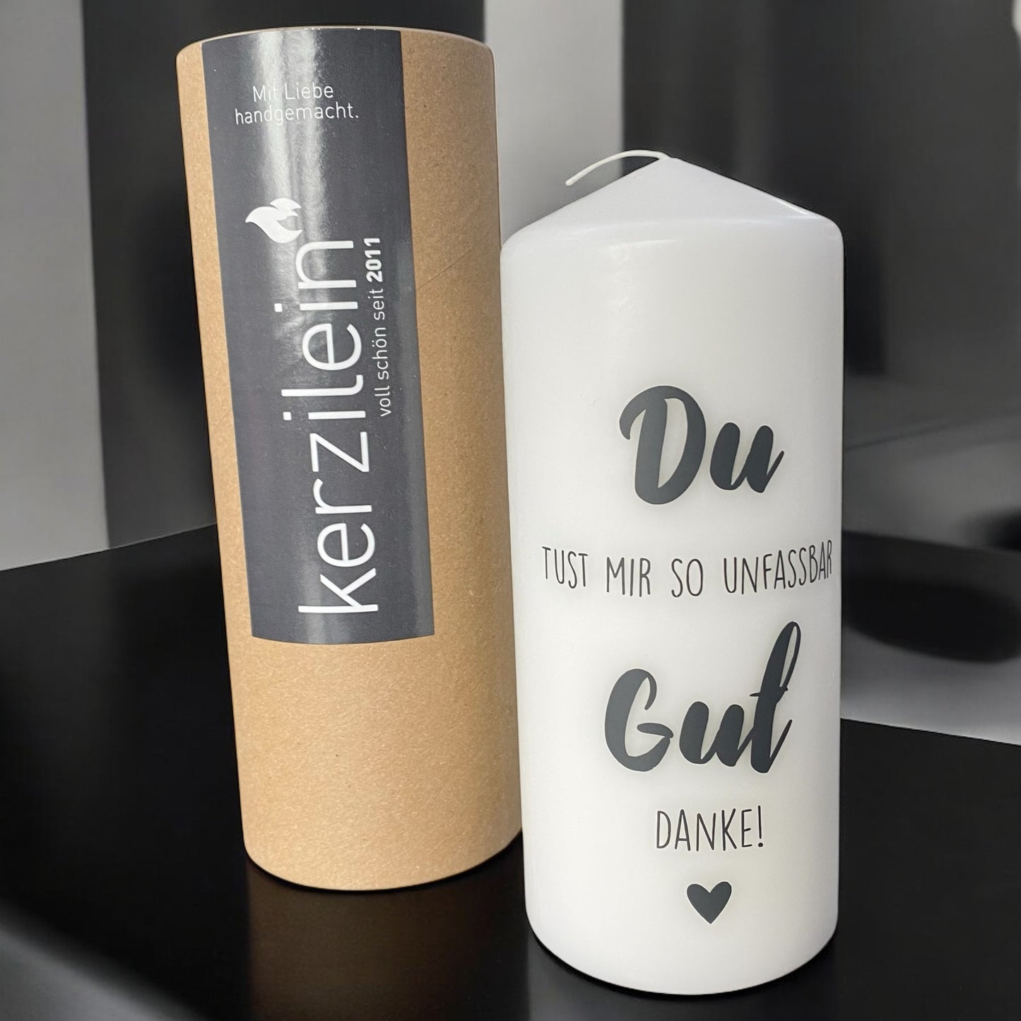 Weiße, große Stumpenkerze mit Spruch „Du tust mir so unfassbar gut – Danke!“ im Ambiente