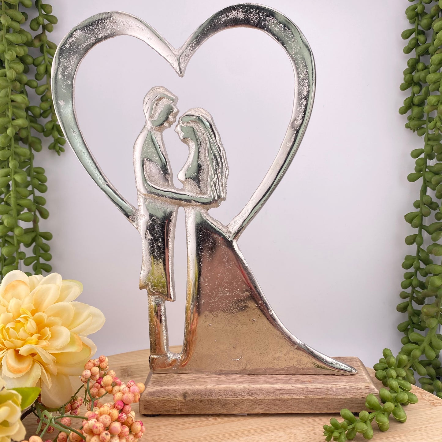 Deko Aufsteller auf Holzsockel mit Ehepaar bei Hochzeit mit Herz aus Aluminium im Ambiente platziert, 26cm groß.