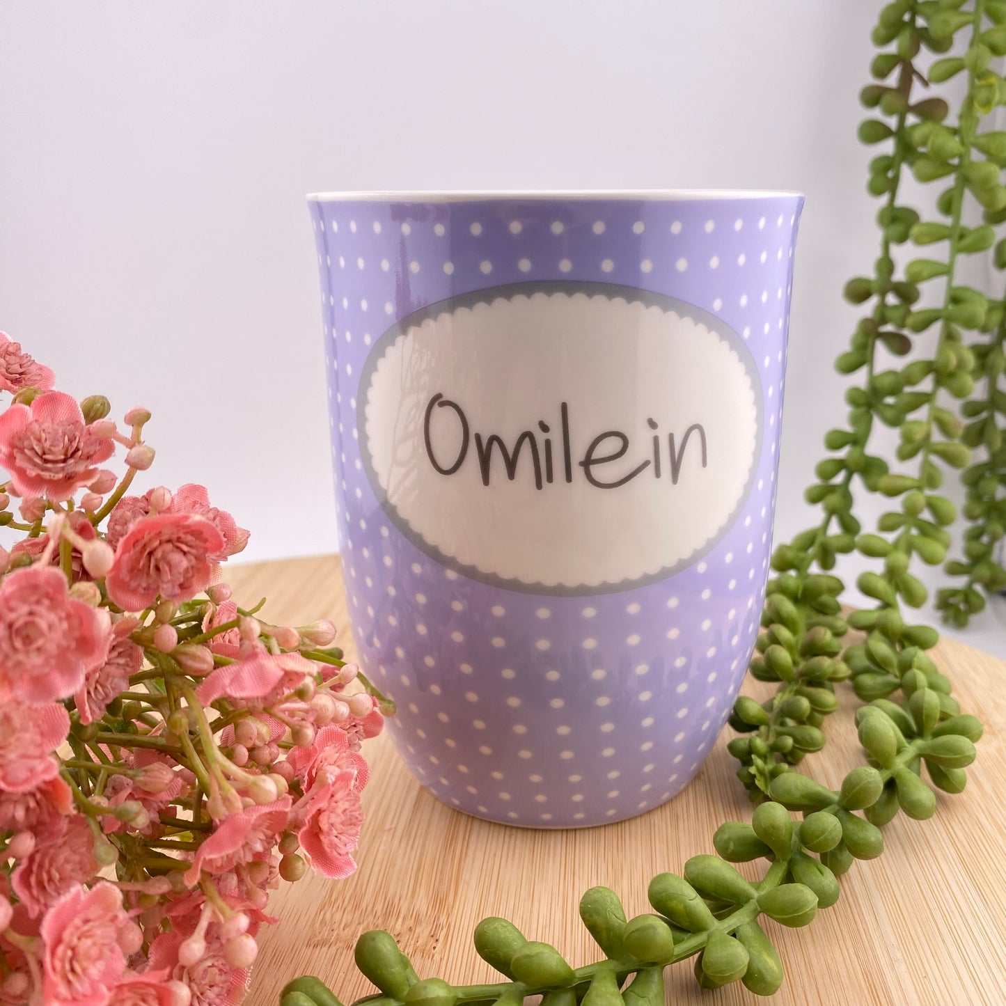 Tasse mit dem Aufdruck Omilein im Ambiente platziert