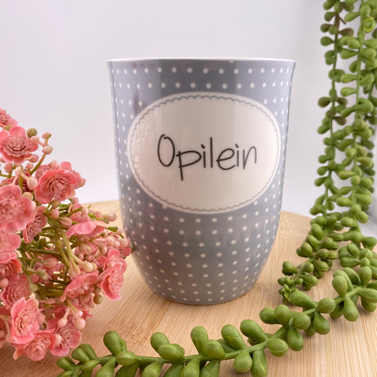 Tasse mit dem Aufdruck Opilein im Ambiente platziert