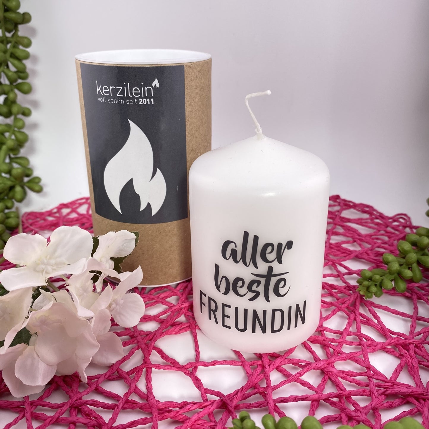 Eine kleine, weiße Kerze mit schwarzem Schriftzug "Aller beste Freundin". Die Dekokerze ist 8cm groß und im Ambiente platziert.