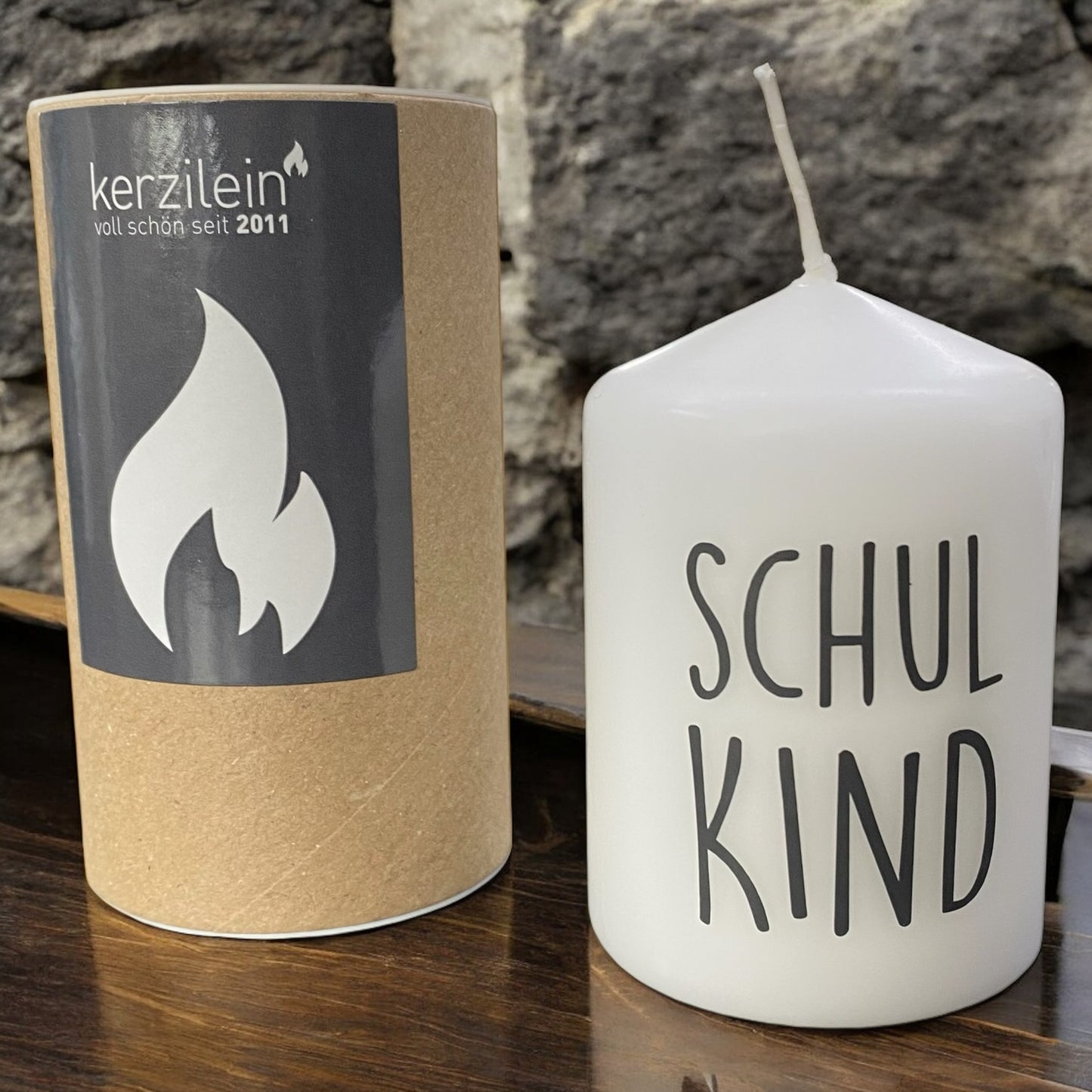 Weiße Stumpenkerze mit schwarzem Schriftzug „Schulkind" im Ambiente