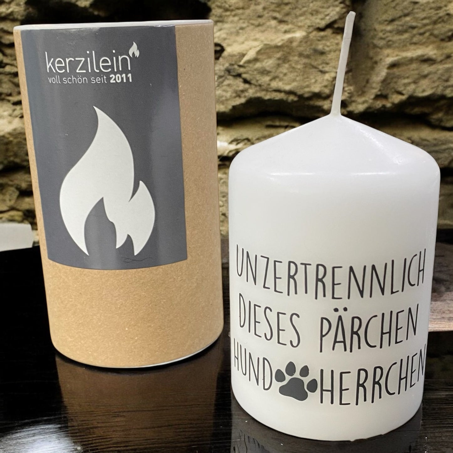 Weiße Stumpenkerze mit Spruch „Unzertrennlich dieses Pärchen – Hund & Herrchen“ und Pfotenmotiv im Ambiente