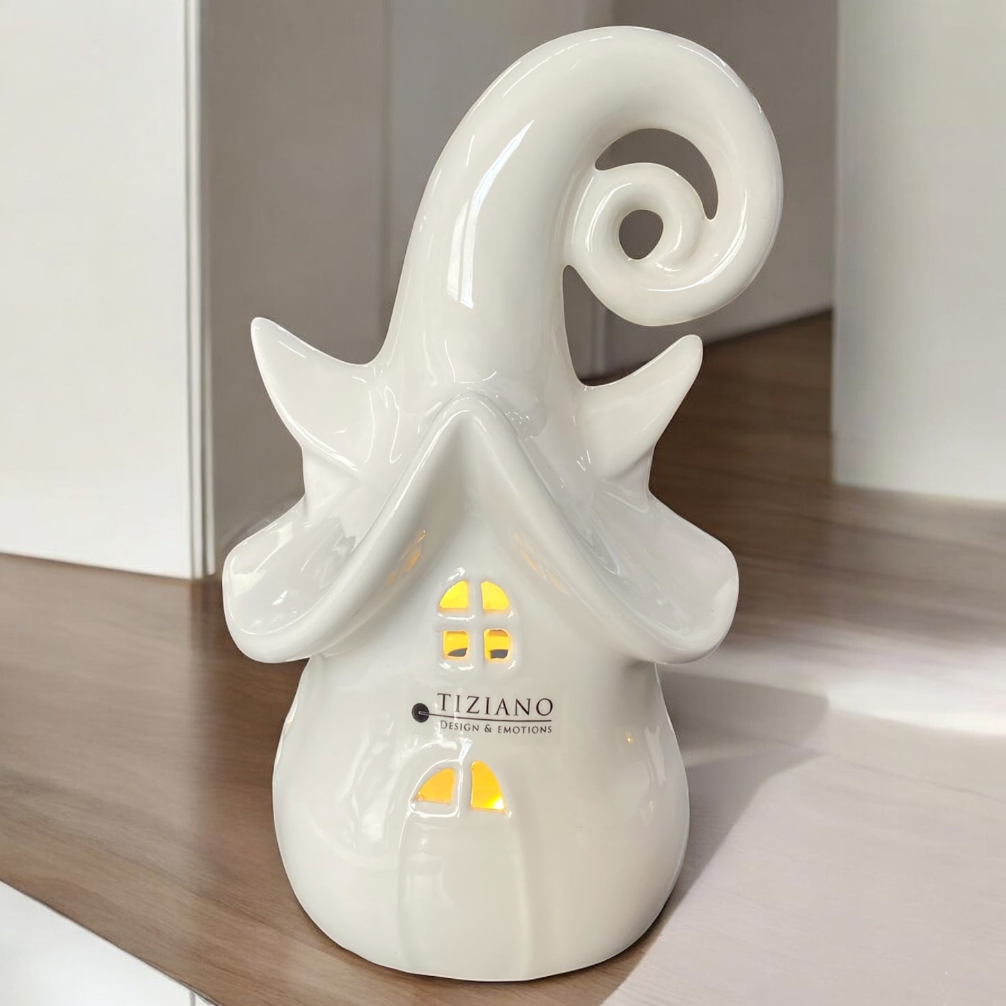 Ein weißes hohes Keramikhaus von Tiziano mit LED Beleuchtung, Märchenhaus-Design, mit geschwungenem Dach im Ambiente