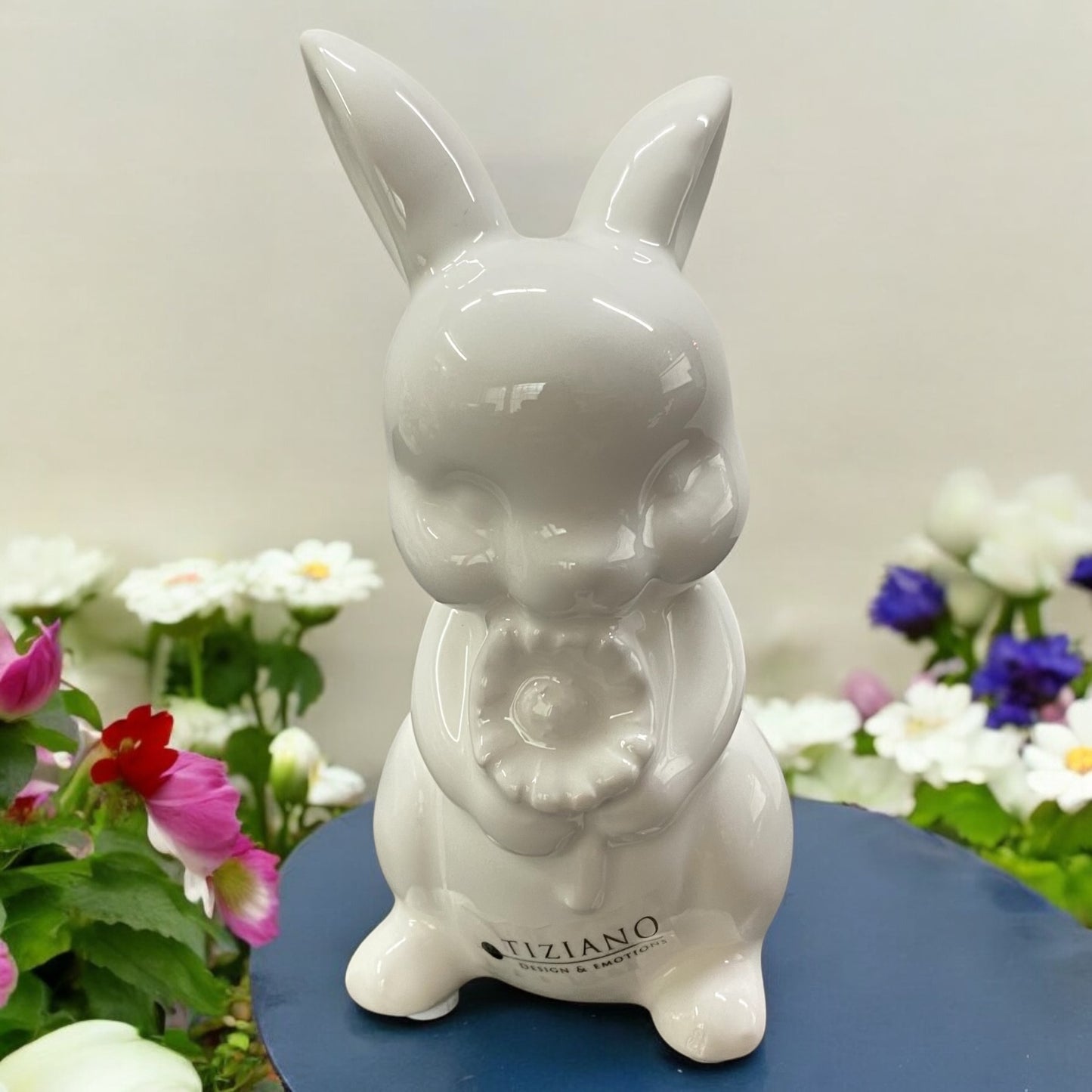 Kleiner Deko Keramik Osterhase der Marke Tiziano, der stehend eine Blume in der Hand hält, im Ambiente