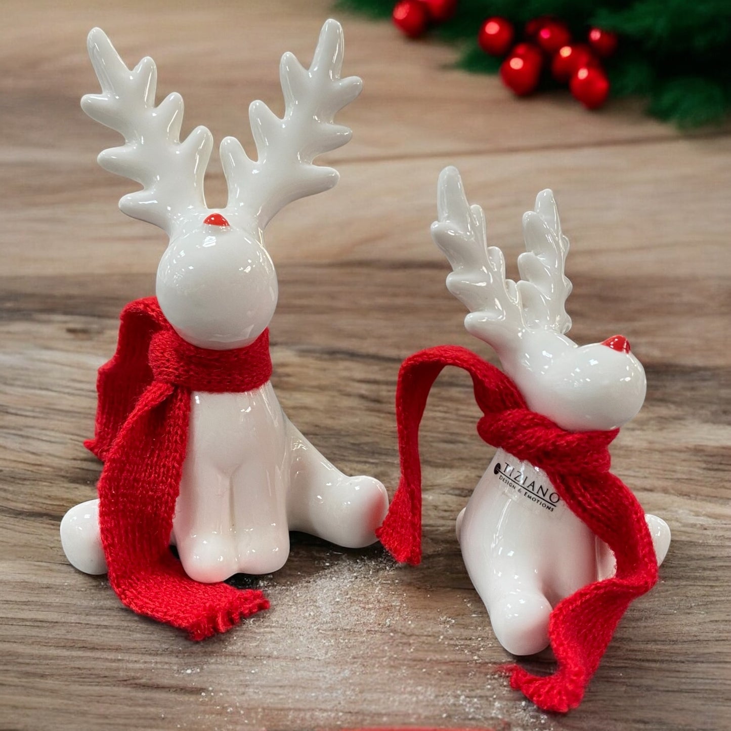 Zwei creme-weiße Keramik Rentiere mit rotem Schal sitzend von Tiziano im Ambiente