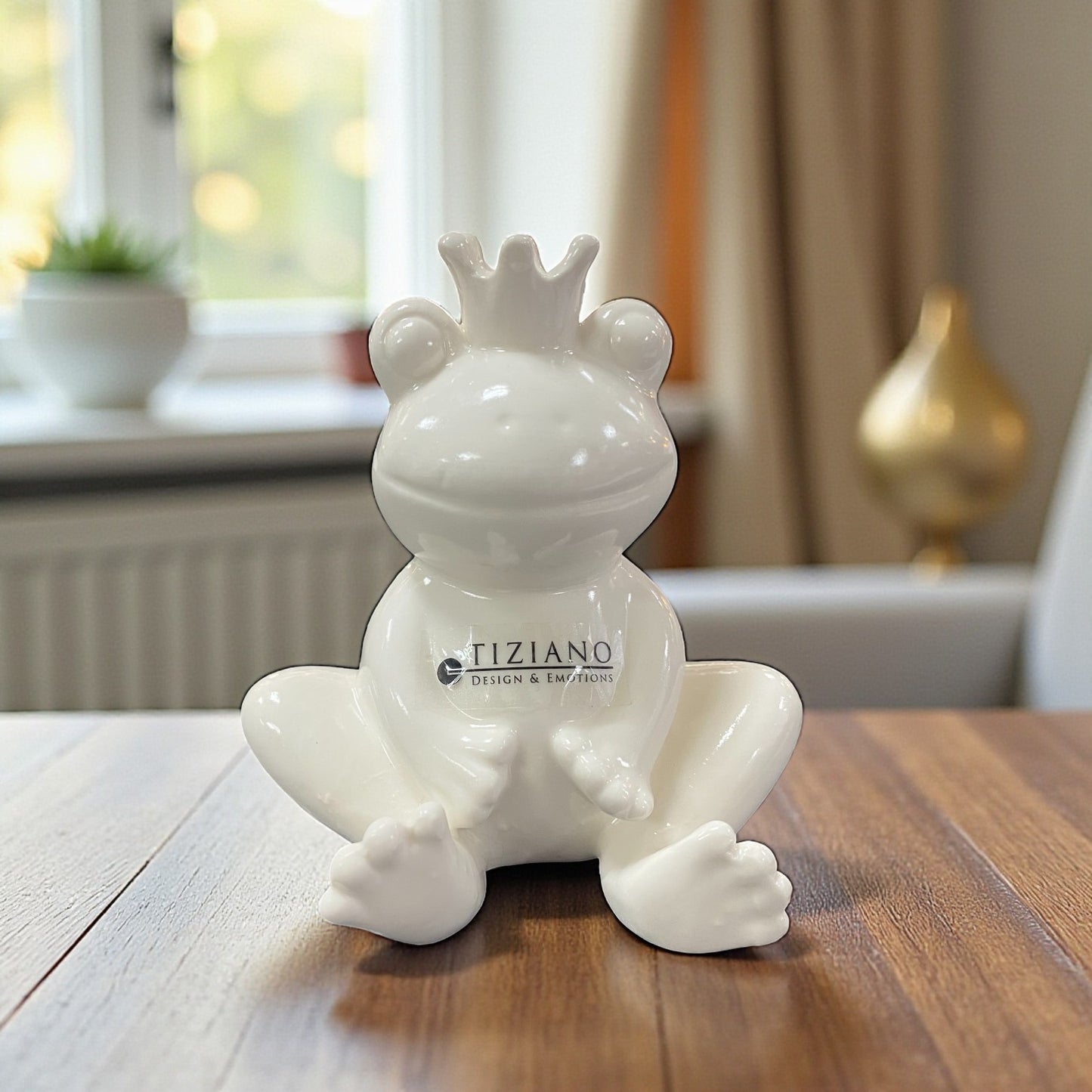 Weiße Keramik-Froschfigur Vico mit Krone – sitzend, entspannte Pose, auf Holzmöbel dekoriert