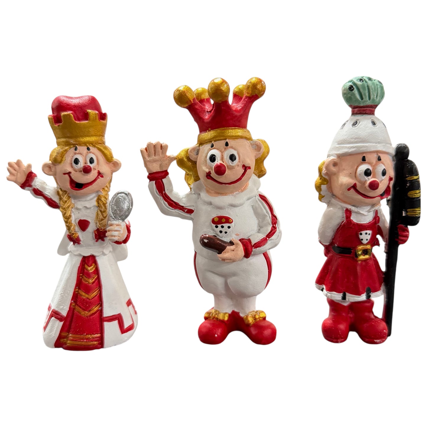 Clown-Dekofiguren als Karnevals-Dreigestirn Bauer, Prinz und Jungfrau auf weißem Hintergrund.