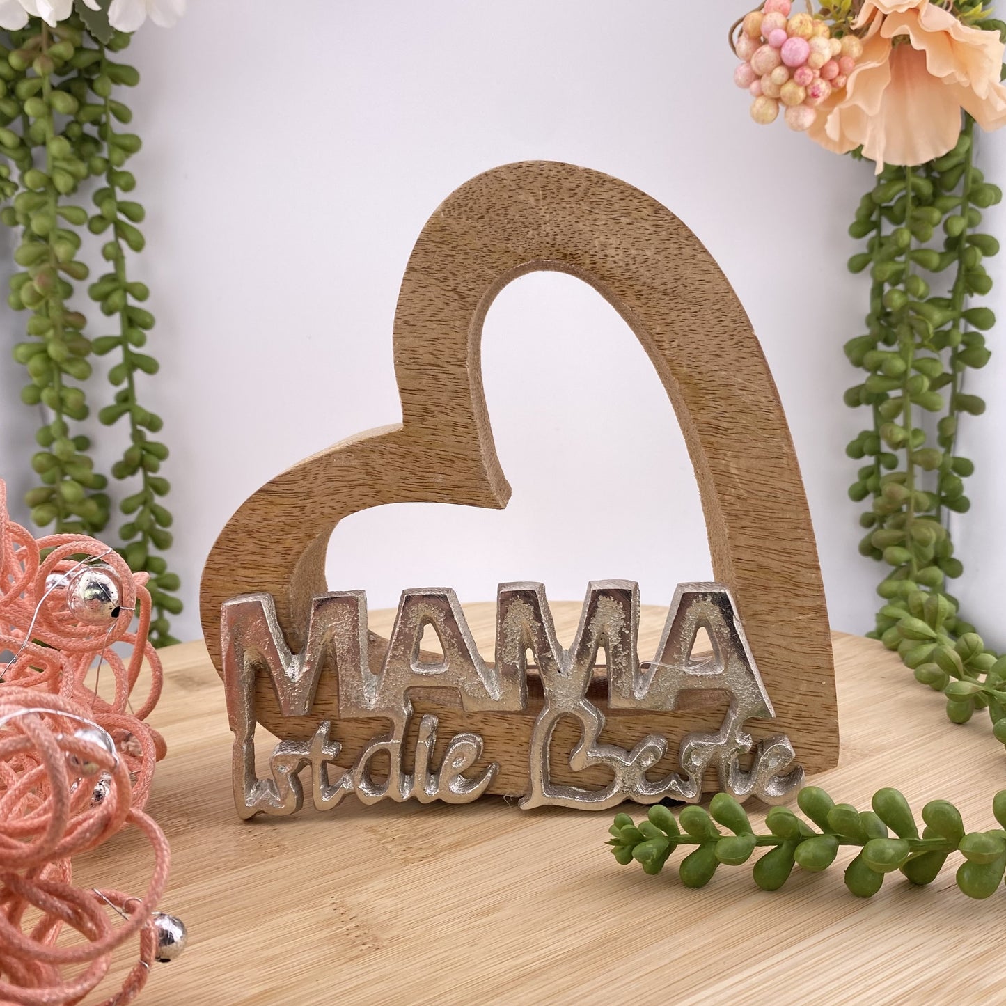 Deko Herz aus Holz mit Schrift "Mama ist die Beste" aus Aluminium im Ambiente platziert.