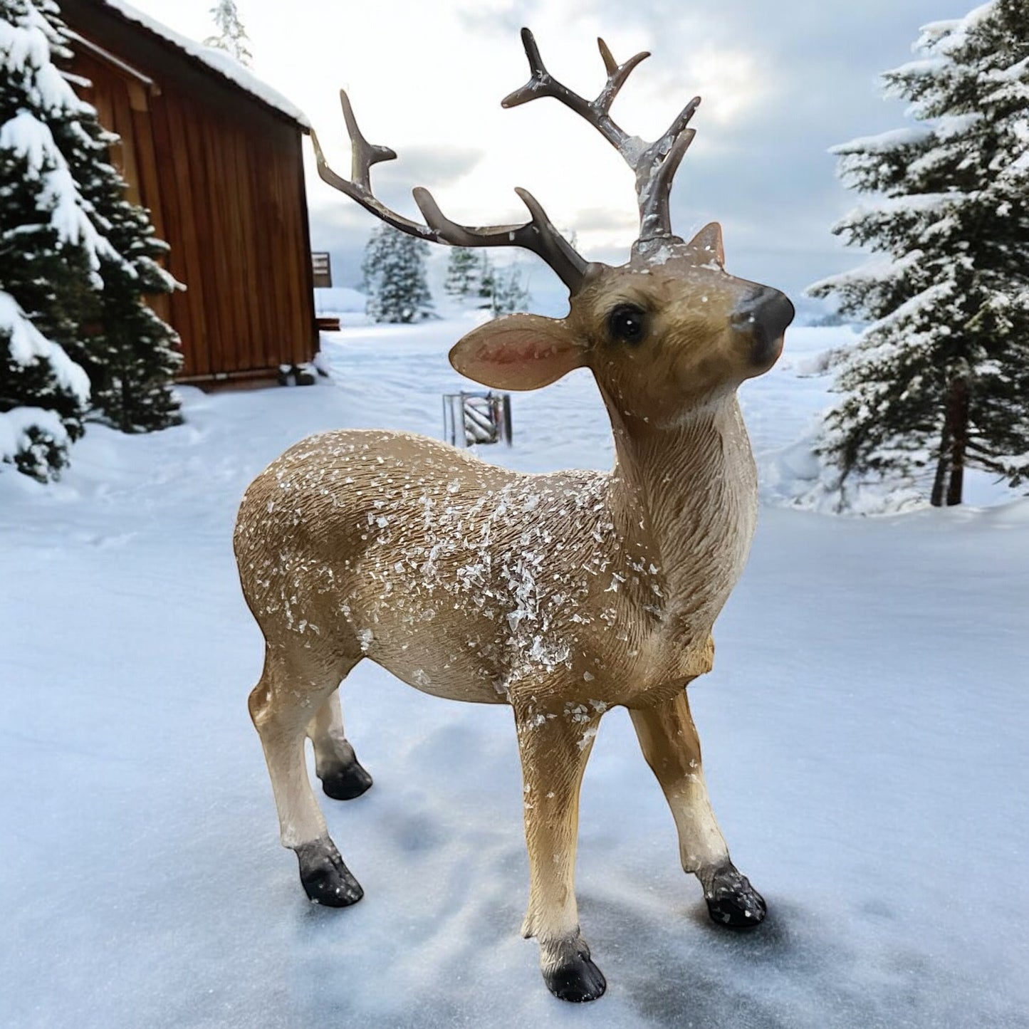 Dekorative Hirschfigur mit Geweih im Schnee vor winterlicher Landschaft, detailreiche Weihnachtsdekoration.