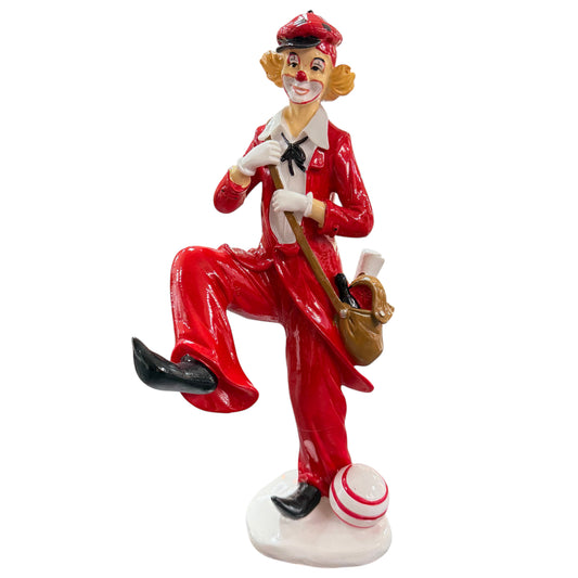 Clown-Dekofigur in Rot mit Umhängetasche und Ball auf weißem Hintergrund.