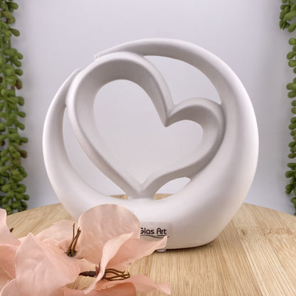 Weiße Dekofigur, die ein Herz in einem Kreis im Ambiente abbildet.