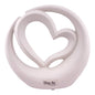Weiße Dekofigur, die ein Herz in einem Kreis vor weißem Hintergrund abbildet.