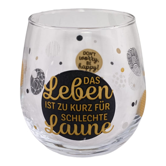 Glas mit Spruch "Das Leben ist zu kurz für schlechte Laune. Dont Worry Be Happy" vor weißem Hintergrund