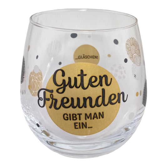 Glas mit Schrift "Guten Freunden gibt man ein Gläschen!" vor weißem Hintergrund