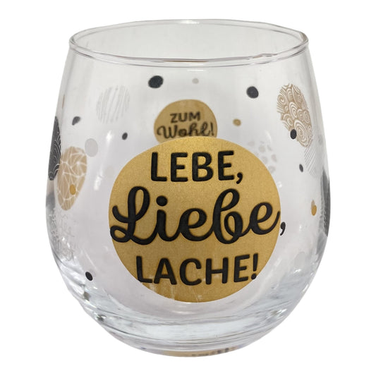 Glas mit Schriftzug "Lebe, Liebe, Lache! Zum Wohl!" vor weißem Hintergrund