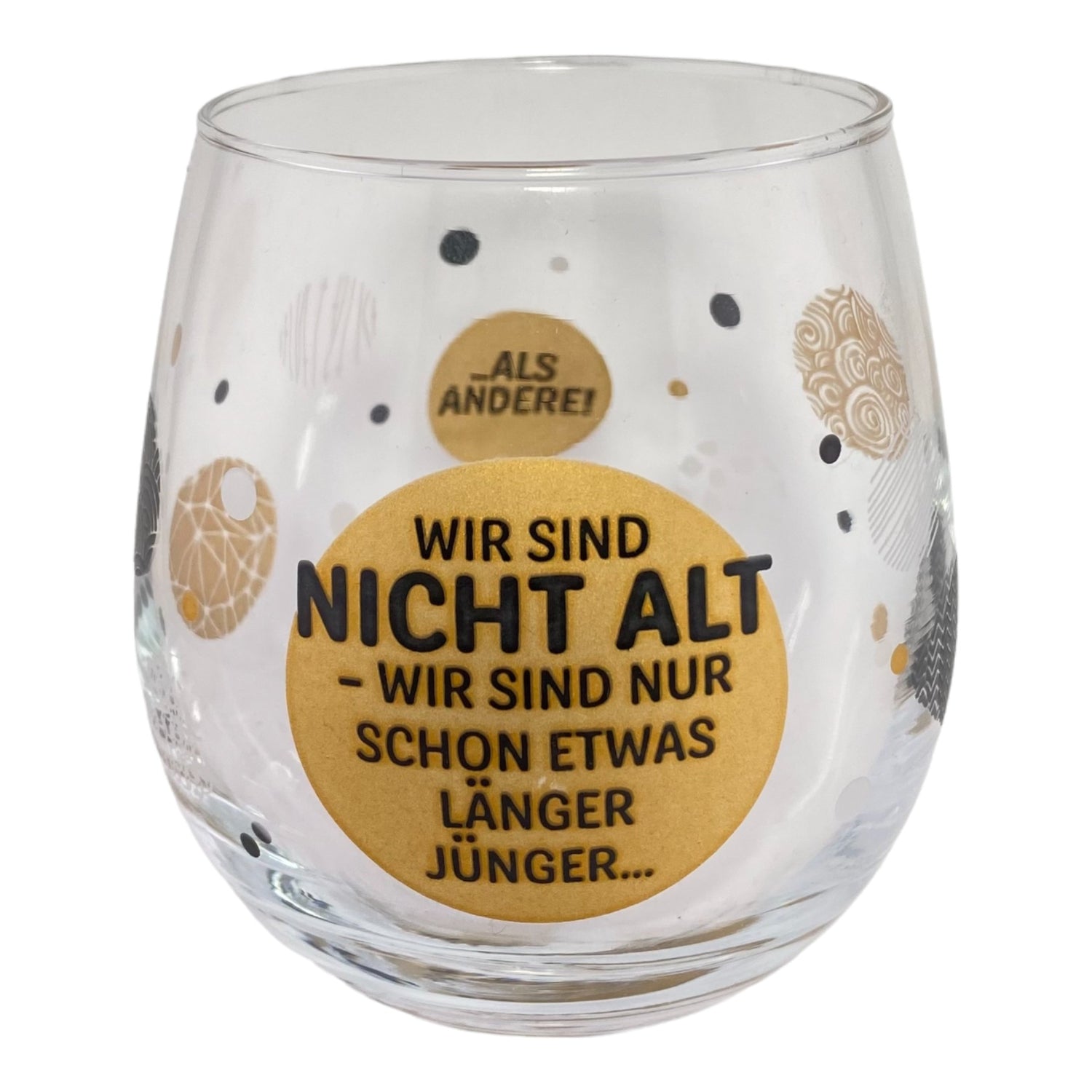 Glas mit Spruch "Wir sind nicht alt - wir sind nur schon etwas länger jünger als andere" vor weißem Hintergrund