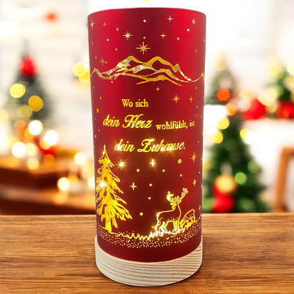 Großes rotes Deko-Licht mit goldenen Akzenten, beleuchtetem Hirschmotiv und dem Spruch „Wo sich dein Herz wohlfühlt, ist dein Zuhause“, vor weihnachtlich geschmücktem Raum.