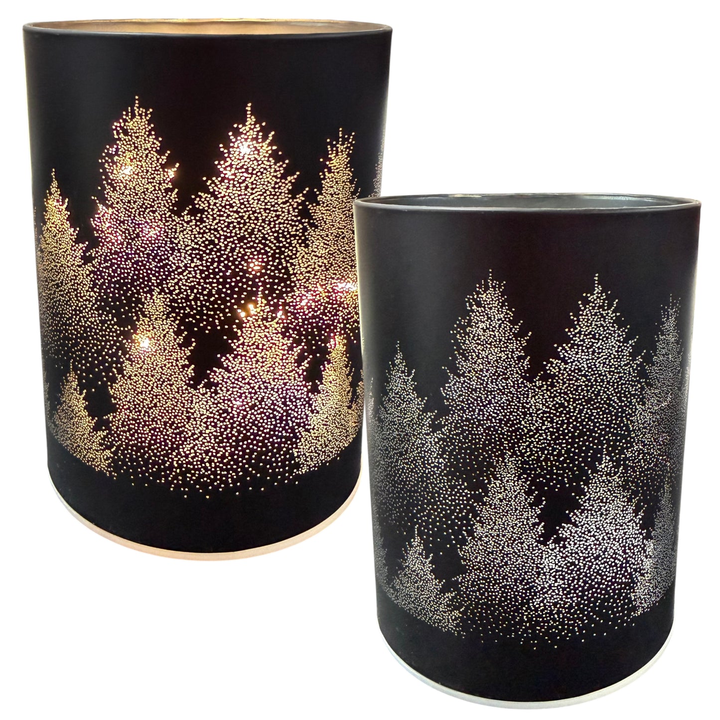 Zwei zylindrische schwarze Dekolichter mit perforiertem Tannenbaum-Motiv und hellem Innenlicht sind vor weißem Hintergrund dargestellt.
