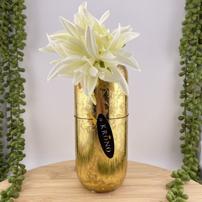 Eine große, goldene Blumenvase in Zylinder Form ist im Ambiente platziert.