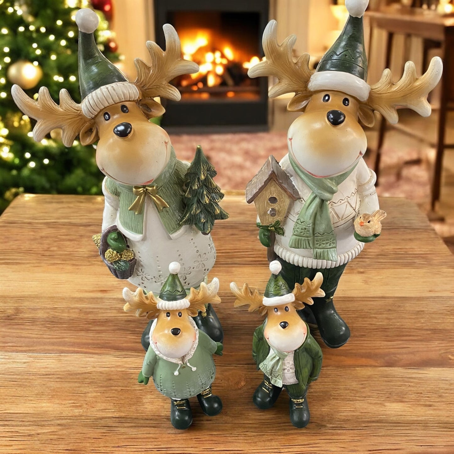 Vier weihnachtliche Elchfiguren mit Geweih und grüner Kleidung, bestehend aus zwei großen und zwei kleineren Figuren im Familien-Set im Ambiente