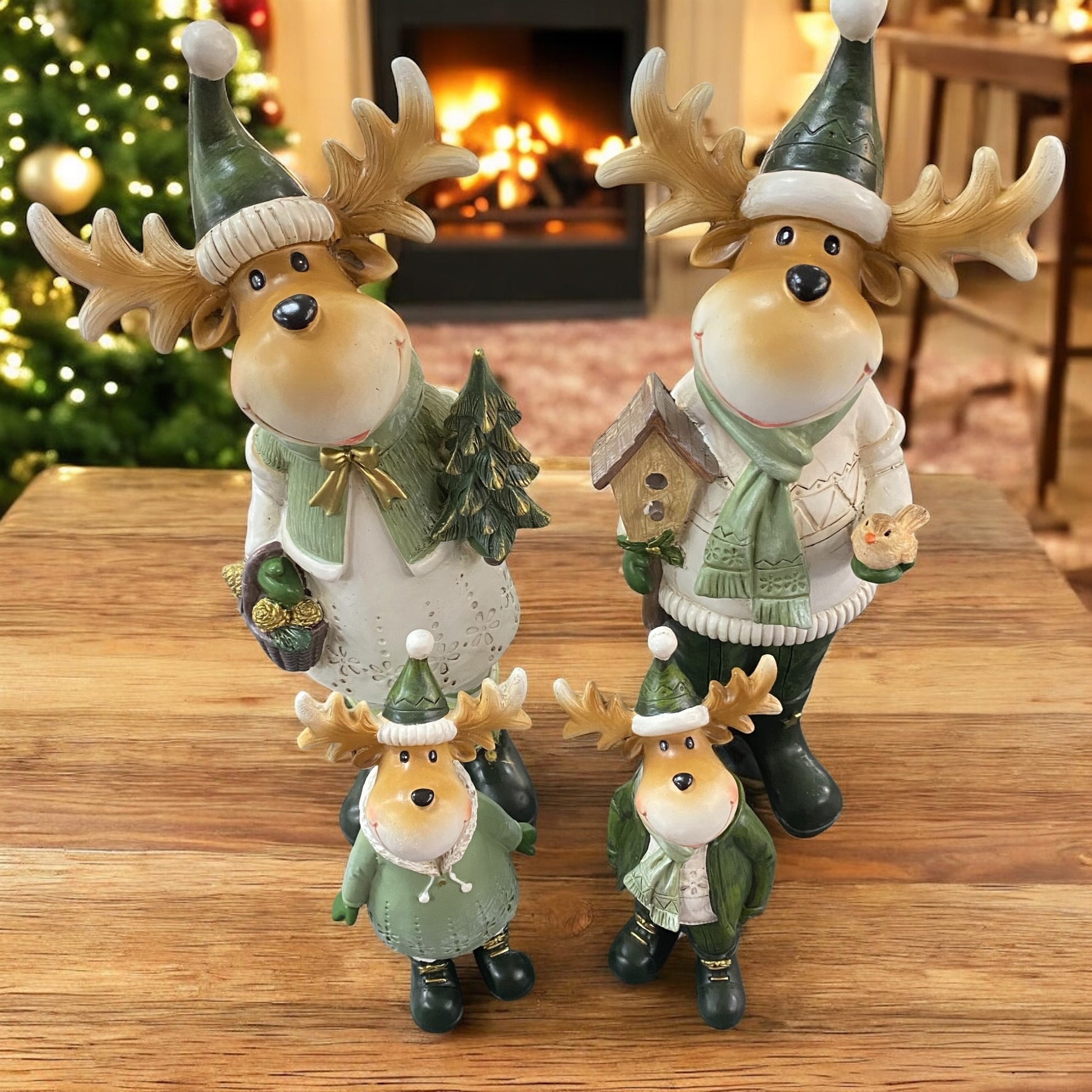 Vier weihnachtliche Elchfiguren mit Geweih und grüner Kleidung, bestehend aus zwei großen und zwei kleineren Figuren im Familien-Set im Ambiente