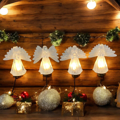 Vier transparente Acryl-Engelfiguren mit Flügeln und warmweißer Beleuchtung, jeweils mit unterschiedlichen Motiven in den Händen – Trompete, Vogel, betend und Herz im Ambiente