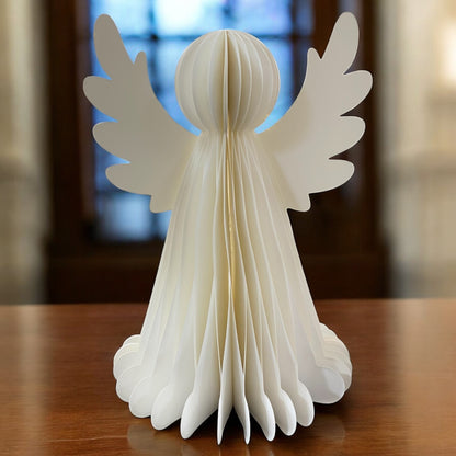 Eine weiße Papier-Engelfigur mit Flügeln und LED-Beleuchtung im Ambiente.