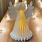 Eine weiße Papier-Engelfigur mit Flügeln und LED-Beleuchtung, die warm von innen leuchten im Ambiente.