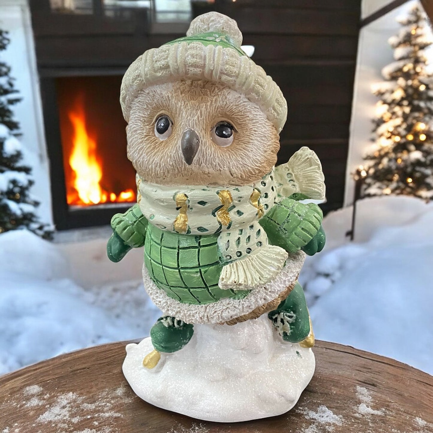 Kleine Eulenfigur mit grüner Mütze und Schlittschuhen, detailreich vor winterlichem Kaminhintergrund dargestellt.