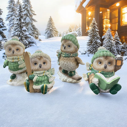 Niedliche Eulenfiguren mit Winterkleidung und Accessoires wie Ski und Buch in verschneiter Landschaft vor Hütte.