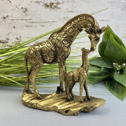 Giraffe mit Kind in Gold im Ambiente platziert