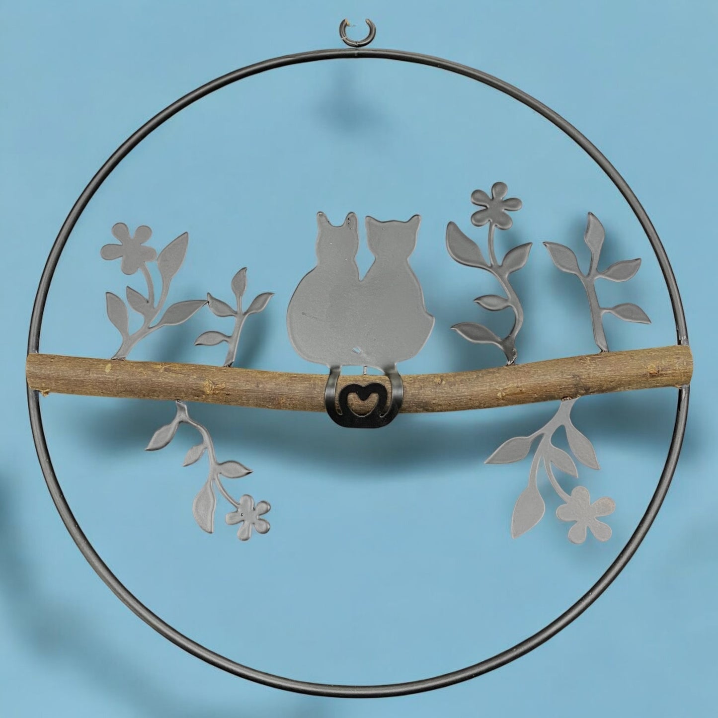 Ein Dekohänger aus einem Metall-Kreis mit Katzenpaar und Holzstange als Fensterdekoration zum Aufhängen im Ambiente