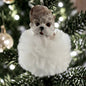 Ein Hunde-Anhänger auf flauschiger Wolke wird stimmungsvoll vor Weihnachtsbeleuchtung präsentiert.