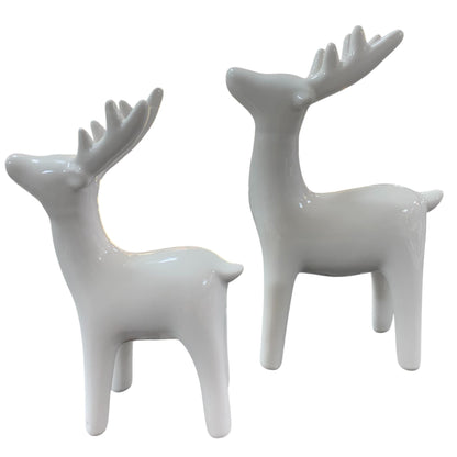 Zwei elegante Hirschfiguren aus cremeweiß glasierter Keramik, stilvolle Winter- und Weihnachtsdekoration.