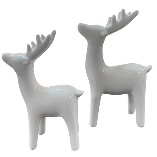 Zwei elegante Hirschfiguren aus cremeweiß glasierter Keramik, stilvolle Winter- und Weihnachtsdekoration.