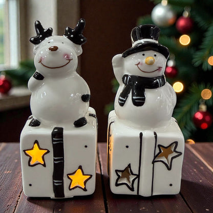 Keramik-Rentier und Keramik-Schneemann auf Geschenken mit sichtbarer LED-Beleuchtung in den Stern-Aussparungen.