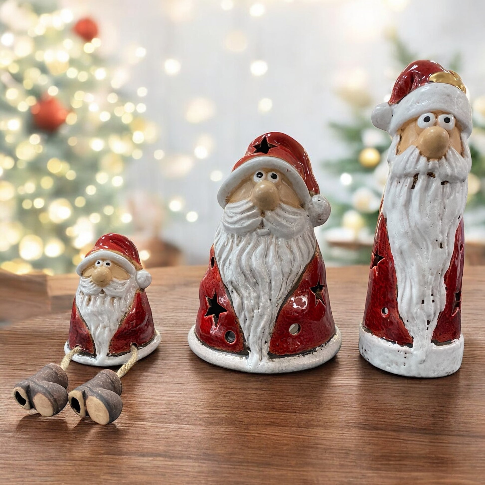 Drei Weihnachtsmannfiguren aus Keramik mit rotem Mantel und weißem Bart, eine als Kantenhocker, zwei als Teelichthalter im Ambiente