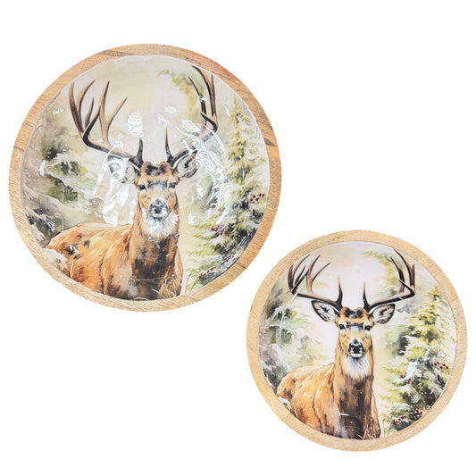 Zwei runde Schalen mit hellem Holzrand vor weißem Hintergrund. Innen jeweils ein Hirschmotiv mit Geweih in winterlicher Landschaft mit Bäumen und Schnee. Unterschiedliche Größen, nebeneinander angeordnet.