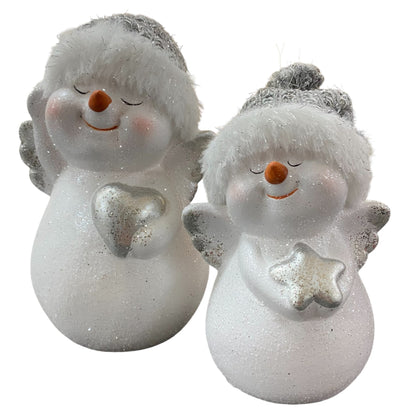 Zwei weiße Schneemannfiguren mit silbernen Flügeln und Mützen, eine hält ein Herz, die andere einen Stern.